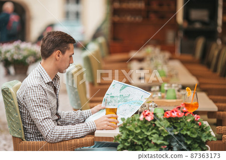 Carefree young man searching for place of destination Carefree young man searching for place of destination 87363173