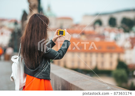Young woman taking selfie on smartphone on Charles Bridge in Prague, Young woman taking selfie on smartphone on Charles Bridge in Prague, 87363174
