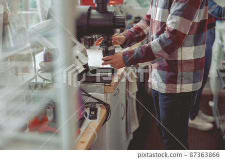 Young barista filling jar with coffee powder Young barista filling jar with coffee powder 87363866
