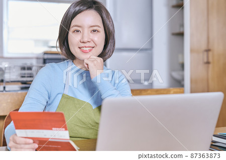 A young woman looking at the camera with a passbook A young woman looking at the camera with a passbook 87363873