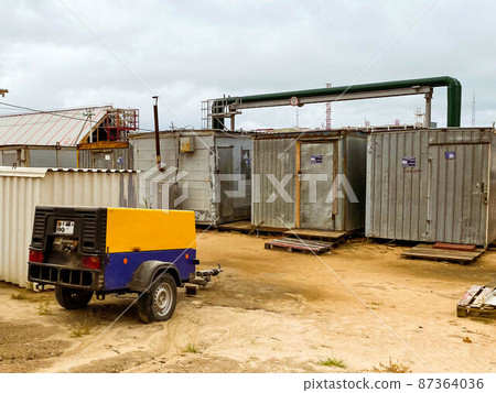 construction site. houses for the life of builders and foremen. next to a makeshift residential town, a car for transporting workers. poor area of the city construction site. houses for the life of builders and foremen. next to a makeshift residential town, a car for transporting workers. poor area of the city 87364036