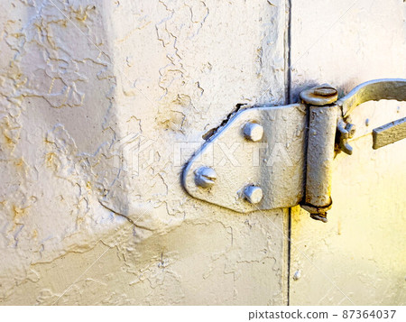 shutter of the old door to the booth. housing for builders. temporary house for people. gray metal door attached to a large hinge shutter of the old door to the booth. housing for builders. temporary house for people. gray metal door attached to a large hinge 87364037