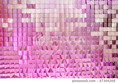 in purple light. Wall Made Of Many Square Sparkling Sequins. Photo Zone 87364269