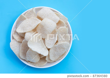 Prawn crackers on blue background. Shrimp crispy rice snack Prawn crackers on blue background. Shrimp crispy rice snack 87364380
