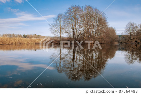Spring landscape in early spring. River, trees without leaves, reflection in the water 87364488