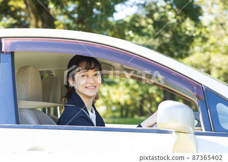 Woman driving a car in a suit Woman driving a car in a suit 87365402