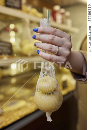 Delicious fresh Caciocavallo and Scamorza cheese hanging. Italian cheeses close up. The cheeses are handmade. The production of cheese. Delicious fresh Caciocavallo and Scamorza cheese hanging. Italian cheeses close up. The cheeses are handmade. The production of cheese. 87366519