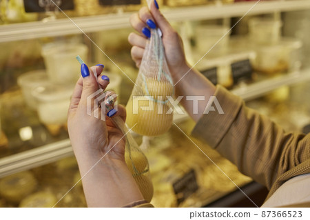 Delicious fresh Caciocavallo and Scamorza cheese hanging. Italian cheeses close up. The cheeses are handmade. The production of cheese. Delicious fresh Caciocavallo and Scamorza cheese hanging. Italian cheeses close up. The cheeses are handmade. The production of cheese. 87366523