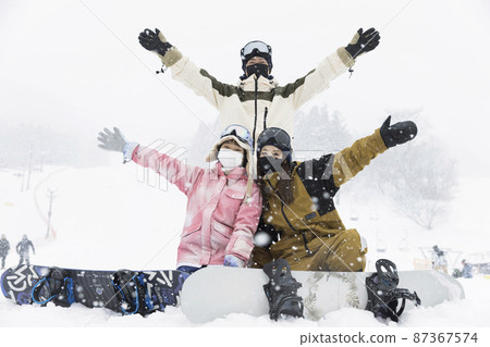 Parents and children enjoying snowboarding even in the snow Parents and children enjoying snowboarding even in the snow 87367574