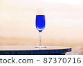 Navy blue champagne glass and copy space that blends into the landscape 87370716