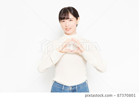 Woman standing in front of white background and making an OK gesture Woman standing in front of white background and making an OK gesture 87370801