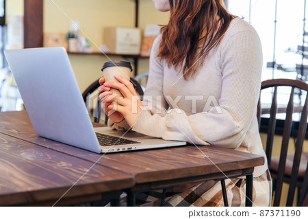 用咖啡操作電腦的女性單手工作 用咖啡操作電腦的女性單手工作 87371190