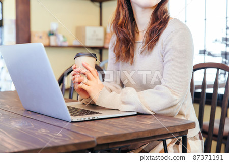 用咖啡操作電腦的女性單手工作 用咖啡操作電腦的女性單手工作 87371191