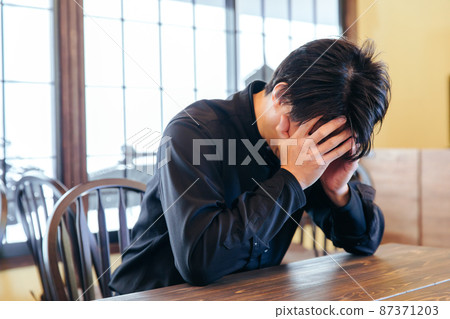 A man holding his head and worrying to worry 87371203