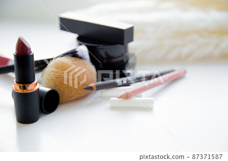 Two pencils for eyes and lips, lipstick, brushes, blush lie together on white background. High quality photo 87371587