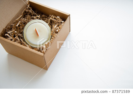 An open box with candles in a glass flask stands on a white background, close-up photo with space for text. High quality photo 87371589