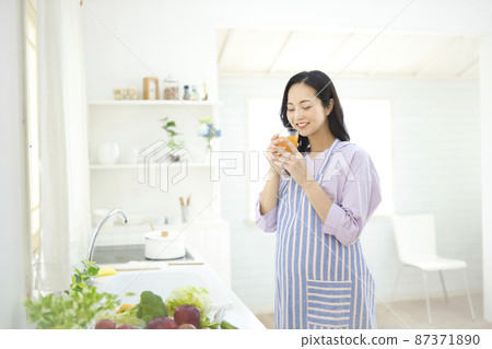 孕婦在廚房裡喝橙汁 孕婦在廚房裡喝橙汁 87371890