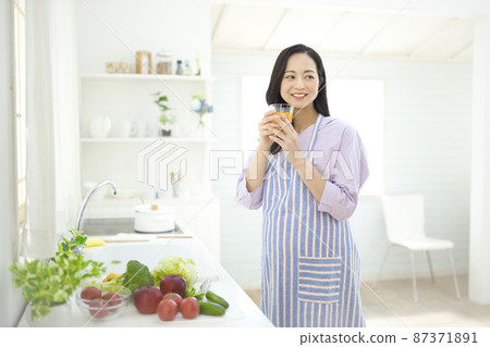 孕婦在廚房裡喝橙汁 孕婦在廚房裡喝橙汁 87371891