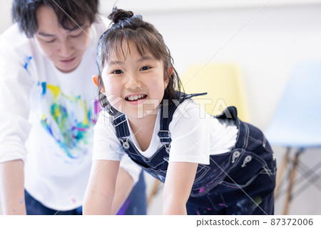 Girl and dad paint on large drawing paper Girl and dad paint on large drawing paper 87372006