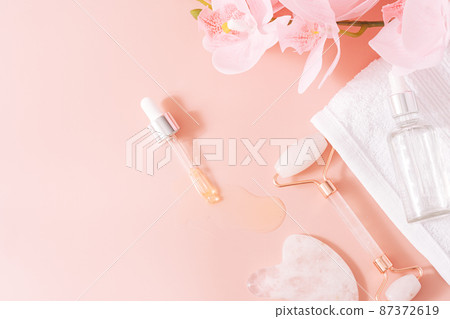 Massage tools on pink background with orchid Massage tools on pink background with orchid 87372619