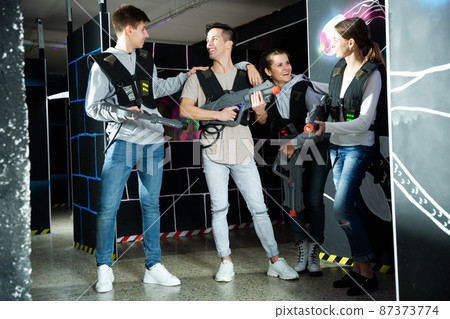 Friends talking on lasertag gaming arena Friends talking on lasertag gaming arena 87373774