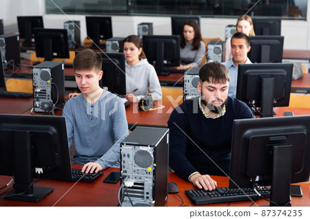 Group of people learning to use computers in classroom 87374235