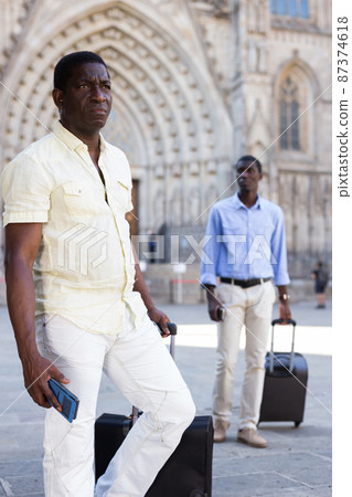 African-american tourists taking walk in the town with the travel bag African-american tourists taking walk in the town with the travel bag 87374618