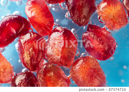 Pomegranate seeds macro. Background of pomegranate berries close-up in water Pomegranate seeds macro. Background of pomegranate berries close-up in water 87374710
