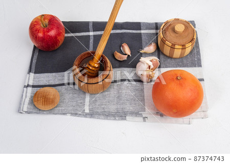 Fermented apple, grapefruit garlic cloves honey, a rich source of probiotics, white background Fermented apple, grapefruit garlic cloves honey, a rich source of probiotics, white background 87374743