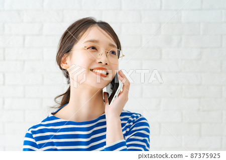 A woman talking on a smartphone 87375925