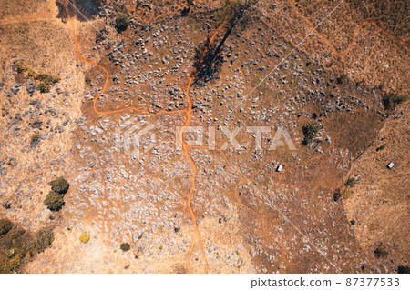 Rocks and farmland are dry during the hot summer days. 87377533
