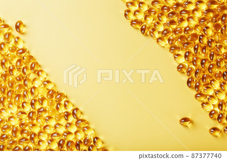 Capsules in a shell with liquid vitamin D3 on a yellow background and a place for text 87377740