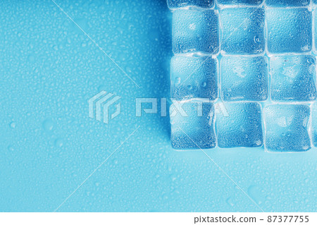 Ice made of cubes lined up with drops on a blue background Ice made of cubes lined up with drops on a blue background 87377755
