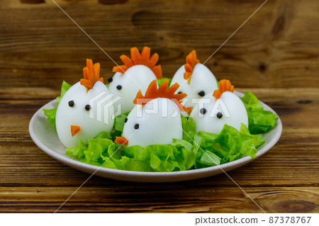Funny easter breakfast with boiled eggs as chicks on wooden table 87378767