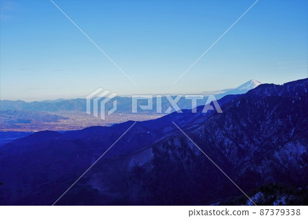 冬天的開駒山 從黑戶嶺刀口穿越的甲府和富士山的街景 冬天的開駒山 從黑戶嶺刀口穿越的甲府和富士山的街景 87379338