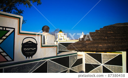 Traditional Ndebele hut at Botshabelo near Mpumalanga, South Africa 87380438