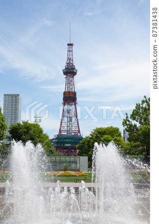 The fountain that erupts in the summer park and the towering TV tower in the back 87381438