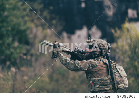 A bearded soldier in uniform of special forces in a dangerous military action in a dangerous enemy area. Selective focus  87382905