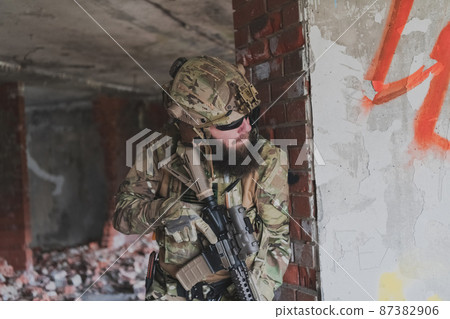 A bearded soldier in uniform of special forces in a dangerous military action in a dangerous enemy area. Selective focus A bearded soldier in uniform of special forces in a dangerous military action in a dangerous enemy area. Selective focus 87382906