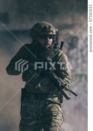 A bearded soldier in uniform of special forces in a dangerous military action in a dangerous enemy area. Selective focus A bearded soldier in uniform of special forces in a dangerous military action in a dangerous enemy area. Selective focus 87382915