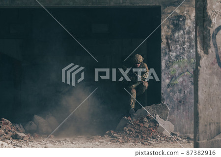 A bearded soldier in uniform of special forces in a dangerous military action in a dangerous enemy area. Selective focus  87382916