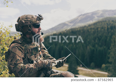 War concept. Bearded soldier in uniform of special forces in dangerous military action in dangerous enemy area studies attack tactics. Selective focus War concept. Bearded soldier in uniform of special forces in dangerous military action in dangerous enemy area studies attack tactics. Selective focus 87382965