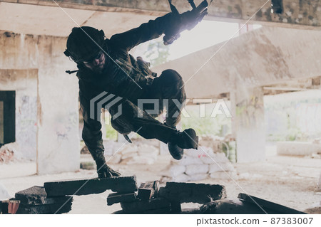 A bearded soldier in uniform of special forces in a dangerous military action in a dangerous enemy area. Selective focus A bearded soldier in uniform of special forces in a dangerous military action in a dangerous enemy area. Selective focus 87383007