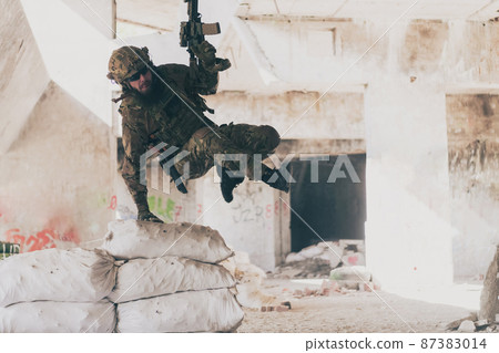 A bearded soldier in uniform of special forces in a dangerous military action in a dangerous enemy area. Selective focus A bearded soldier in uniform of special forces in a dangerous military action in a dangerous enemy area. Selective focus 87383014