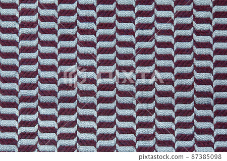Knitted texture. Texture of jacquard fabric with gray blue geometric pattern. Crochet mosaic pattern. Knitted texture. Texture of jacquard fabric with gray blue geometric pattern. Crochet mosaic pattern. 87385098