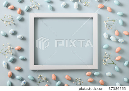 Easter mock up with pastel chocolate eggs on blue background. Easter mock up with pastel chocolate eggs on blue background. 87386363