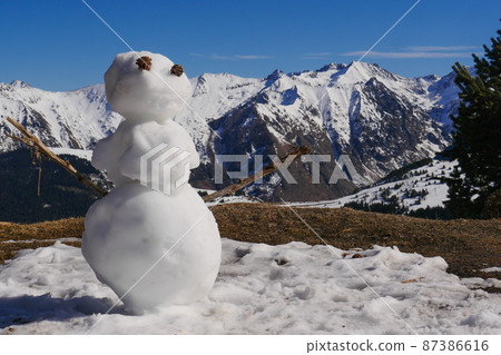 France, Ariege, Snowman in Mountains Pyrenees, winter sports scene, skiers on the slopes 87386616