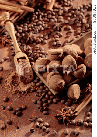 Chocolate truffles and a wooden spoon with cacao powder. Chocolate truffles and a wooden spoon with cacao powder. 87387915