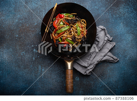 Asian stir fry noodles with vegetables in black wok pan 87388106