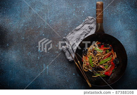 Asian stir fry noodles with vegetables in black wok pan copy space 87388108
